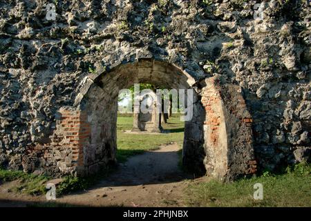 Una porta attraverso un muro, sullo sfondo di una tomba a Fort Speelwijk, uno dei beni culturali in zona ora chiamato Banten lama (Old Banten) a Serang, Banten, Indonesia, in questa foto scattata nel 2010. "La sostenibilità del patrimonio culturale è fortemente legata all'effettiva partecipazione delle comunità locali alla conservazione e alla gestione di queste risorse", secondo un team di scienziati guidati da Sunday Oladipo Oladeji nel loro articolo di ricerca pubblicato su Sage Journals il 28 ottobre 2022. L'area di Banten lama (Old Banten) faceva parte dell'importante porto di Banten... Foto Stock