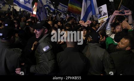 I membri della forza di sicurezza israeliana respingono i manifestanti anti anti anti-governativi che tentano di entrare nel composto della casa privata di PM Benjamin Netanyahu durante una manifestazione in risposta al licenziamento del ministro della Difesa Yoav Galant dopo aver invitato il governo a fermare le sue controverse riforme giudiziarie il prossimo marzo 26, 2023 a Gerusalemme, Israele. Foto Stock