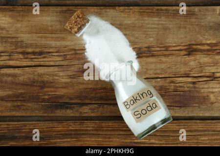 Vaso capovolto con bicarbonato su tavolo di legno, vista dall'alto Foto Stock