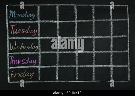 Orario scolastico settimanale disegnato su lavagna nera Foto stock - Alamy