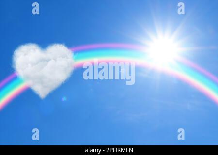 Bella vista di nuvola a forma di cuore, arcobaleno e sole nel cielo blu Foto Stock