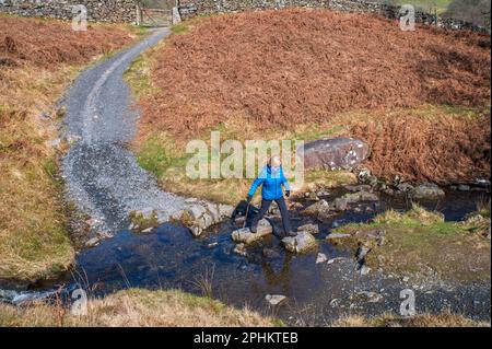 Attraversare le pietre passo su Black Beck a Kentmere, Cumbria Foto Stock
