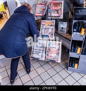 Sandnes, Norvegia, 11 2023 marzo, Donna che si piega o Stooping per acquistare Un giornale da Un News Stand Downtoown Sandnes Foto Stock