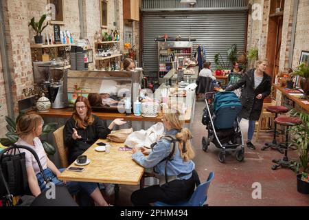 Persone che si godono il caffè in Patchworks caffè, Patchworks Creative Space, Leyton, East London, Inghilterra, Regno Unito. Foto Stock