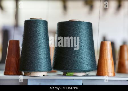 Due bobine con fili industriali su coni Foto Stock
