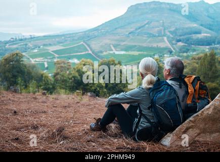 Pensione, escursioni e coppia anziana con relax con vista della collina dal ritorno in Perù in vacanza avventura. Viaggi, uomo anziano e donna che riposano sulla scogliera Foto Stock