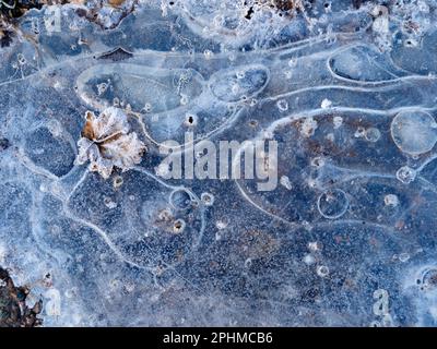 La bellezza è intorno a noi. Ma a volte devi guardare giù... Un recente periodo sostenuto di temperature subzero ha portato a stagni ghiacciati e pozze Thr Foto Stock