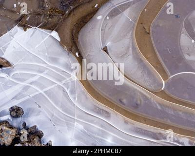 La bellezza è intorno a noi. Ma a volte dovete guardare in giù. Un recente periodo sostenuto di temperature subzero ha portato a stagni ghiacciati e pozze attraverso Foto Stock