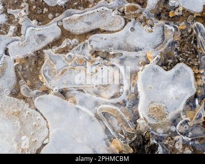 La bellezza è intorno a noi. Ma a volte dovete guardare in giù. Un recente periodo sostenuto di temperature subzero ha portato a stagni ghiacciati e pozze attraverso Foto Stock