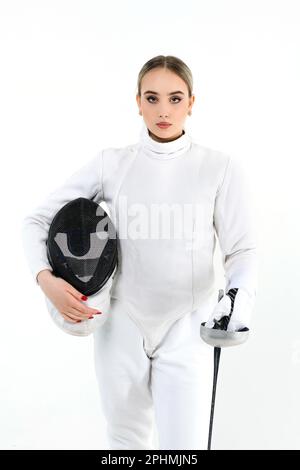 Ragazza reccatore con una spada su uno sfondo bianco. Ritratto di una ragazza in costume da scherma con maschera e spada. Foto Stock