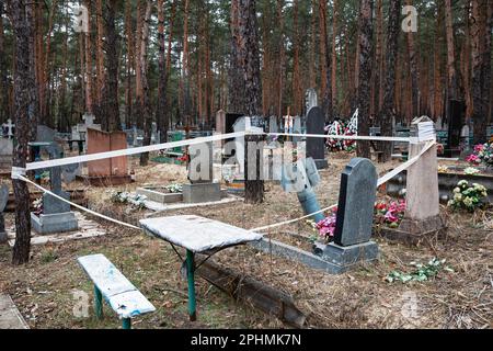 Razzo inesploso recintato per la sicurezza con nastro di avvertimento può essere visto nel cimitero di Izyum, Kharkiv reg, Ucraina Foto Stock