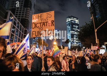 Tel Aviv, Israele. 25th Mar, 2023. I manifestanti israeliani hanno un segno che dice che ìHe è troppo dittatore per functionî durante una manifestazione anti-riforma a Tel Aviv. Oltre 230.000 persone protestano a Tel Aviv contro il governo di estrema destra di Netanyahu e la sua controversa riforma legale. Credit: SOPA Images Limited/Alamy Live News Foto Stock