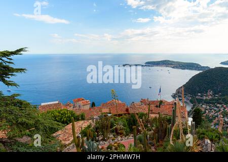 Eze villaggio in un giorno d'estate. Foto del paesaggio costiero con tetti di tegole rosse e mare Mediterraneo. Alpes-Maritimes, Francia Foto Stock