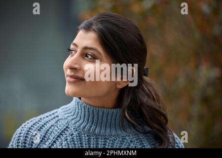 Testa e spalle Ritratto di bella e naturale Donna del Sud Asia all'aperto Foto Stock