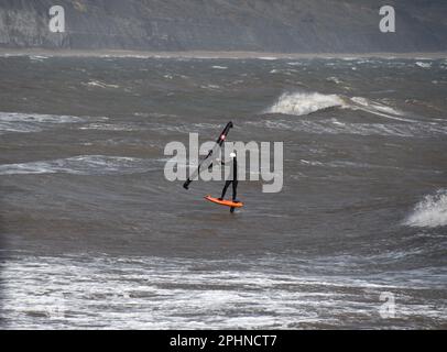 Un surfista alare scivola attraverso un mare mosso alimentato da una brezza rigida al largo della costa Jurrasic nella baia di Lyme. Dorset.UK Foto Stock