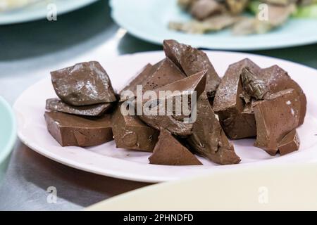 Il sangue di pollo solido o coagulato è una delicatezza tra gli alimenti asiatici. Si tratta di un servizio di sangue di pollo solido servito nel ristorante Thailand. Foto Stock
