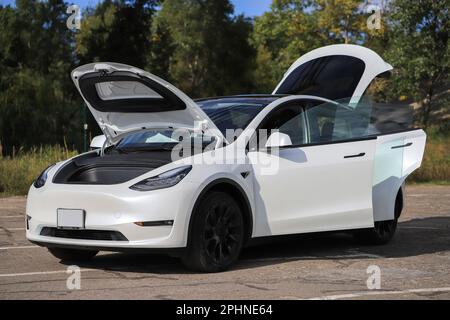 Auto bianca Tesla Model Y con porte aperte Foto Stock