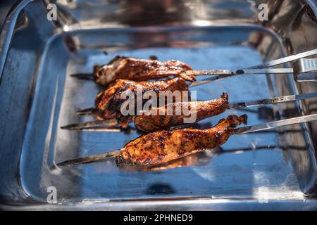 Grigliare gli spiedini con pollo marinato in un recipiente di metallo. Foto Stock