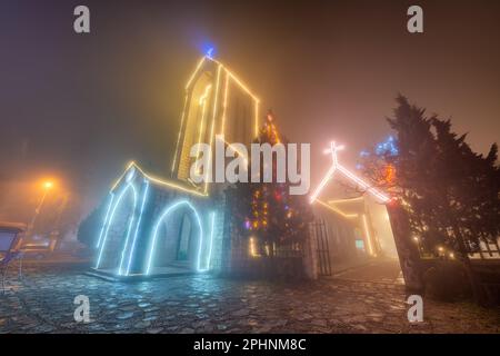 Antica chiesa in pietra di Sapa con cielo notturno nebbia. Destinazione di viaggio più popolare in Sapa, Laocai of Vietnam Foto Stock