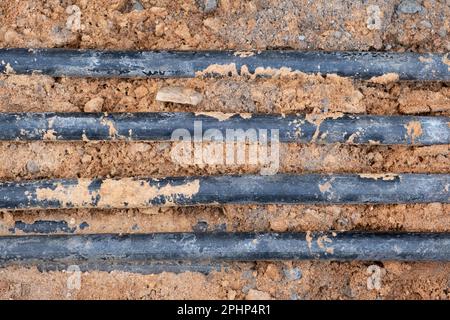 installazione di infrastrutture per cavi elettrici sotterranei. Cantiere con molti cavi di comunicazione protetti in tubi. elettrico e alta-spe Foto Stock