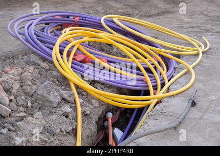 installazione di infrastrutture per cavi elettrici sotterranei. Cantiere con molti cavi di comunicazione protetti in tubi. elettrico e alta-spe Foto Stock