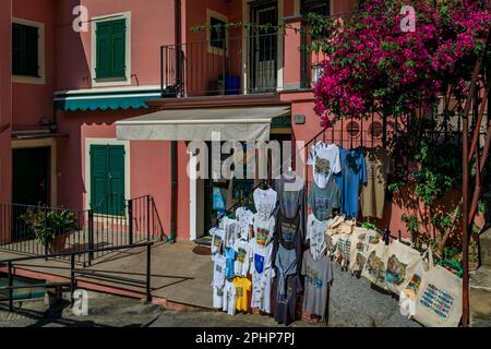 Manarola, Italia - 01 giugno 2022: Magliette ricordo delle cinque Terre in mostra presso un negozio di souvenir in una casa colorata nel centro storico sul Mar Mediterraneo Foto Stock