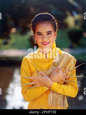 Thailandia. Nakhon Pathom. Giardino delle rose. Giovane donna in costume da ballo tradizionale tailandese. Foto Stock