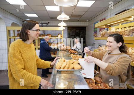 Lo scrittore James Read presso Yasar Halim presso il negozio di alimentari e panetteria, Green Lanes, Harringay Ladder, London Borough of Haringey, Inghilterra, Regno Unito. Foto Stock