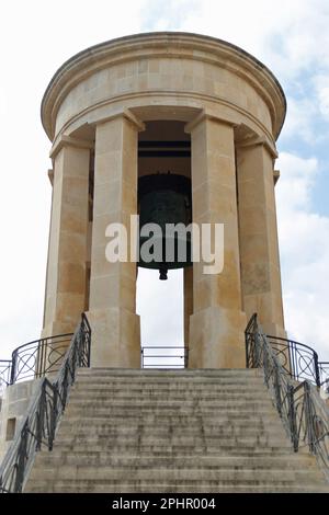 Monumento commemorativo alla Guerra di Assedio - la Valletta. Arroccato sopra il Grand Harbour, il Memoriale della Campana d'Assedio è un semplice monumento che simboleggia la situazione di molte persone che hanno combattuto e sono morte per Malta durante la seconda guerra mondiale. Fu costruito nel 1992 per commemorare il 50th° anniversario di quando Malta ricevette la Croce di Giorgio per la mostra di coraggio e di valore mostrata durante gli attacchi sull'isola dal 1940 al 42. Foto Stock