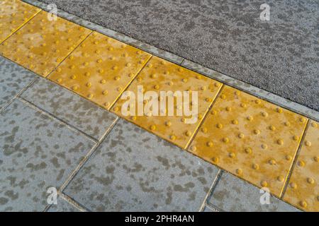 Pavimentazione tattile su Modern Tiles Pathway per disabili ciechi, Passerella di sicurezza per disabili, passeggiata in soletta di rilievo, pathway, percorso in mattone Ro Foto Stock