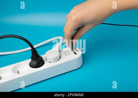 Accensione delle spine USB, presa multipla, cavo di prolunga, presa USB per la ricarica di prese elettriche, presa per la casa, prolunga, cavo su sfondo blu Foto Stock