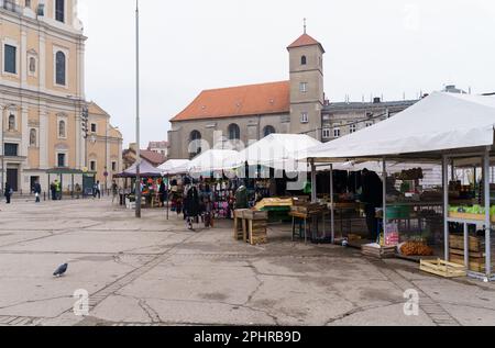 Poznan, Polonia - 20 gennaio 2023: Piccolo mercato sulla piazza vicino alla chiesa. Foto Stock