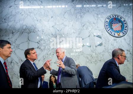 Il senatore degli Stati Uniti Mark Warner (democratico della Virginia), presidente, la commissione di selezione del senato degli Stati Uniti sull'intelligenza, ha lasciato, colloqui con il senatore degli Stati Uniti John Cornyn (repubblicano del Texas) prima di un'audizione della commissione del senato sull'intelligenza per esaminare il personale che vetta la modernizzazione nell'edificio dell'ufficio del senato di Hart a Washington, DC, mercoledì, Marzo 29, 2023. Credito: Rod Lamkey/CNP Foto Stock