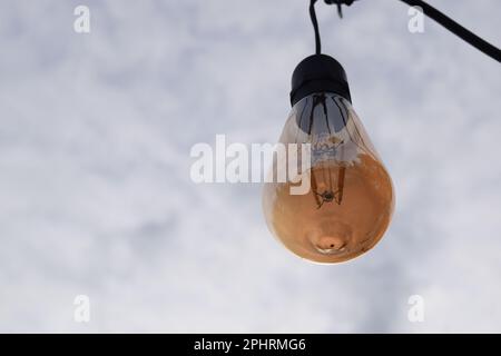 Luce elettrica sul cielo blu in condizioni di sole. Lampada per l'illuminazione del giardino domestico. Foto Stock