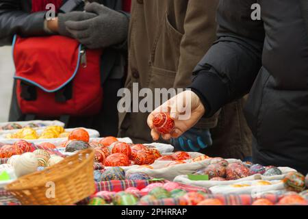 I clienti scelgono e comprano uova dipinte, tradizionali decorazioni pasquali presso il mercato agricolo di Praga Foto Stock