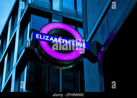 Segno viola per la linea Elizabeth illuminata di notte, Tottenham Court Road, Londra, Regno Unito Foto Stock