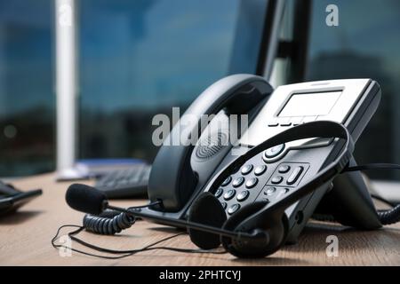 Telefono fisso e cuffia su scrivania in legno interna, guardaroba. Servizio hotline Foto Stock