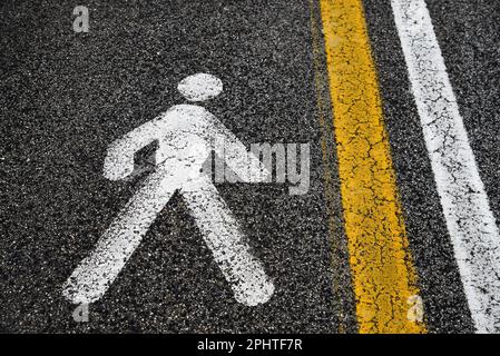 Segnaletica per la zona pedonale e linee stradali dipinte su asfalto all'aperto Foto Stock