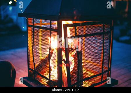 Fuoco luminoso che scoppietta in una fossa di fuoco di notte Foto Stock