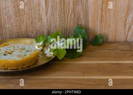 Ghewar o ghevar è un dolce tradizionale di rajasthan. È fatto di latte, farina, ghee e zucchero. Frutta secca e panna malai in cima. E' servito in br Foto Stock