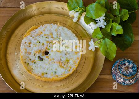 Ghewar o ghevar è un dolce tradizionale di rajasthan. È fatto di latte, farina, ghee e zucchero. Frutta secca e panna malai in cima. E' servito in br Foto Stock