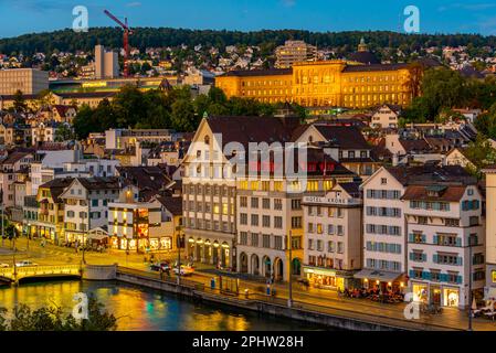 Vista del tramonto sulla sponda orientale del fiume Limmat, con la Predigerkirche e l'Università di Zurigo a Zurigo, Svizzera. Foto Stock