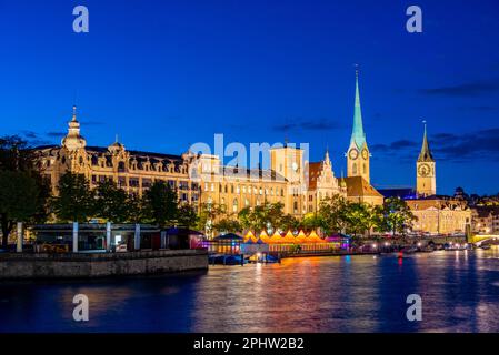 Vista al tramonto del centro storico di Zuerich con la famosa chiesa Fraumuenster e il fiume Limmat in una giornata di sole, in Svizzera. Foto Stock