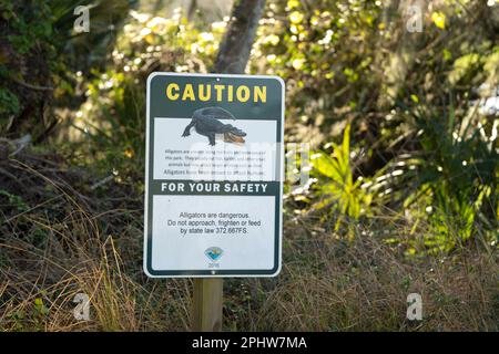 Alligatori segnale di avvertimento nel parco statale della Florida per la prudenza e la sicurezza durante il percorso a piedi Foto Stock