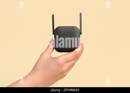 Donna con ripetitore WiFi nero su sfondo beige Foto Stock