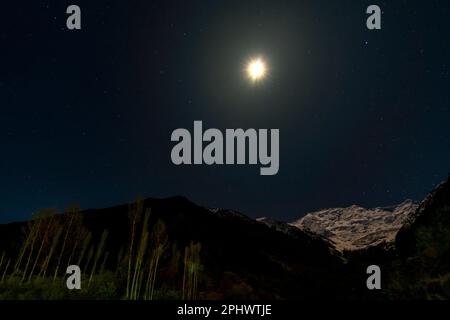 bellissima luna sopra la montagna di neve, rakaposhi di notte con cielo blu e stelle Foto Stock