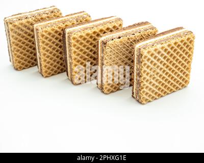 deliziosi wafer ripieni di crema di nocciole su sfondo bianco Foto Stock