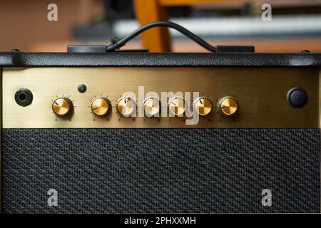 Amplificatore per chitarra con piastra di controllo in oro vuoto con sfondo sfocato Foto Stock