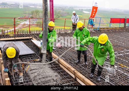 MAANSHAN, CINA - 30 MARZO 2023 - gli operai del secondo ufficio di aviazione della Cina le comunicazioni effettuano il getto concreto per il primo fascio di strada dentro Foto Stock