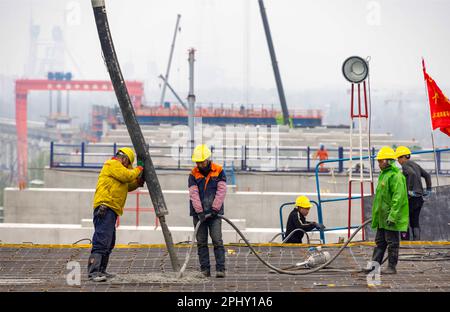 MAANSHAN, CINA - 30 MARZO 2023 - gli operai del secondo ufficio di aviazione della Cina le comunicazioni effettuano il getto concreto per il primo fascio di strada dentro Foto Stock